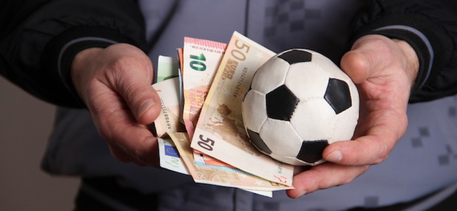 Man_holding_football_and_money_in_his_hands_036b7872a2faa2e89bf46c508f80e549